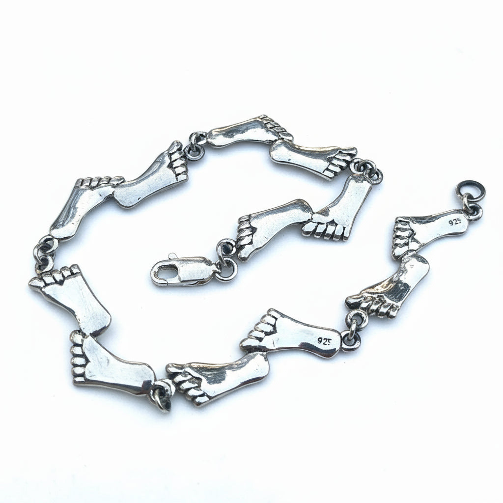 Silver foot-shaped bracelet on a light gray background